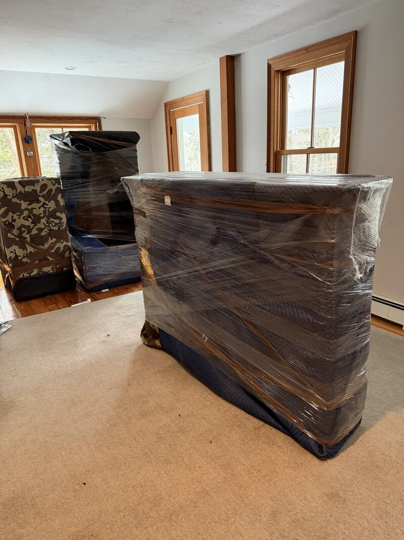 A large piece of furniture shrink-wrapped and padded for a move